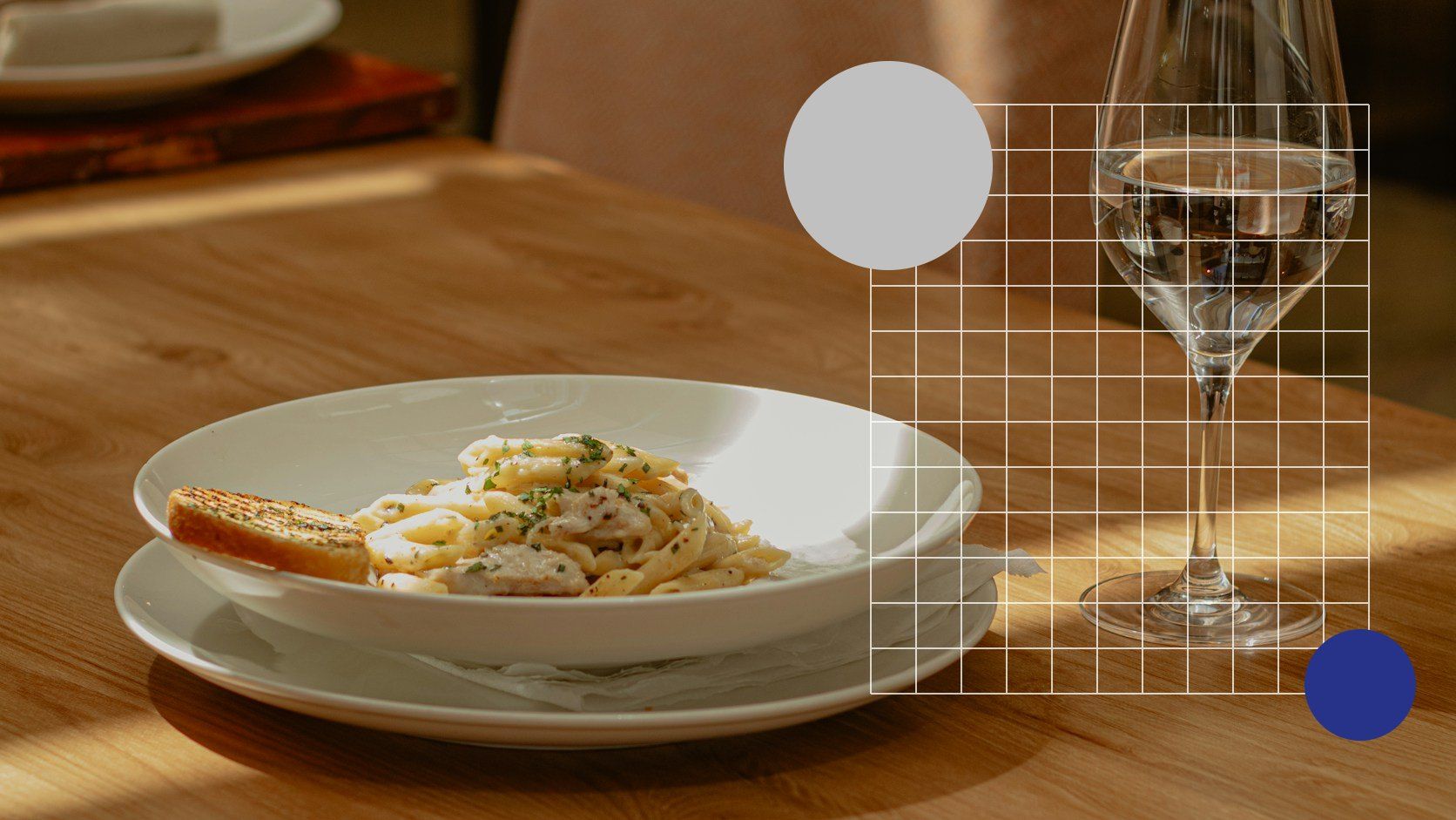 Gedekte tafel met pasta en wijnglas in een restaurant