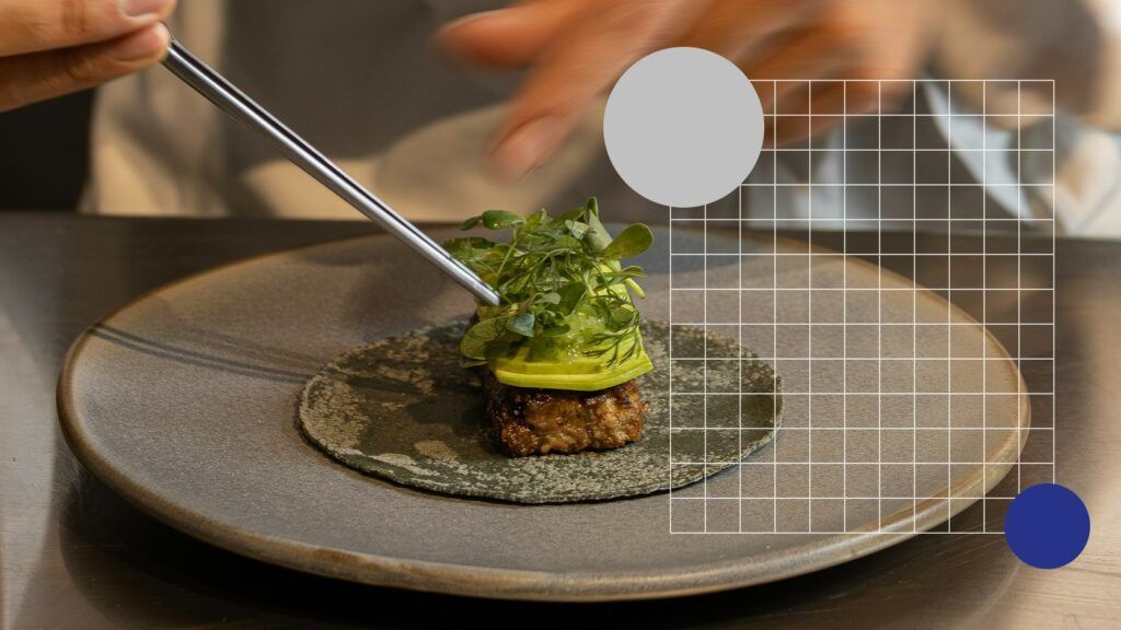 Chef dresseert een gerecht met een pincet op een grijs bord