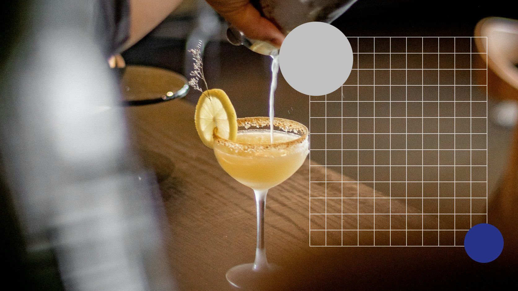 Bartender schenkt een cocktail in een coupeglas met citroen